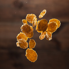 Image showing Falling corn flakes on wooden background