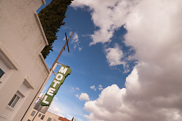 Image showing Neon Motel Sign Clear Blue Sky White Billowing Clouds