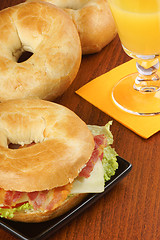 Image showing Bagel with bacon, cheese and lettuce and orange juice