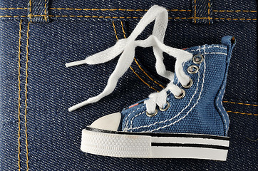 Image showing tiny blue shoe on denim background