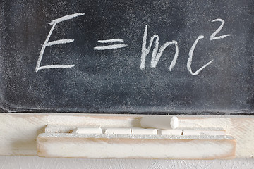 Image showing well-known physical formula written in chalk on the blackboard