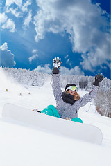Image showing Young girl Oversized sitting with your snowboard in the snow and would be