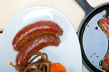 Image showing beef sausages cooked on iron skillet 