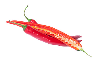 Image showing Two whole and one half red chili peppers deployed
