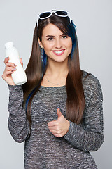 Image showing Healthy woman showing a bottle of dairy produce