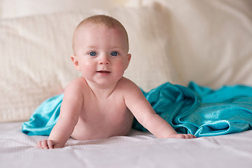 Image showing Young Blue Eyed Infant Boy Laying on Bed Looking 