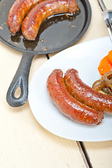 Image showing beef sausages cooked on iron skillet 