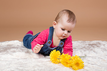 Image showing small infant baby with yellow flowers