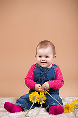 Image showing smiling infant baby with yellow flowers