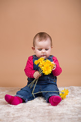 Image showing infant baby with yellow flowers