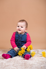 Image showing smiling infant baby with yellow flowers