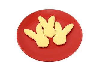 Image showing Three rabbit-shaped cookies for Easter on a red plate