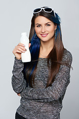 Image showing Healthy woman showing a bottle of dairy produce