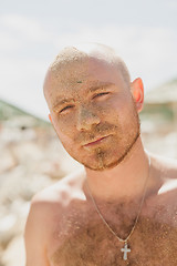 Image showing Half face of a handsome man covered with sand