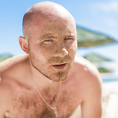 Image showing Half face of a handsome man covered with sand