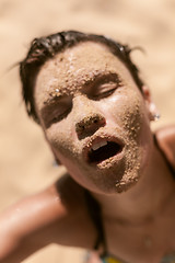Image showing Beautiful girl with sand on face