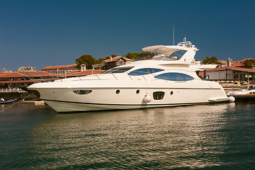 Image showing Row of luxury motorised yachts moored in a sheltered harbour