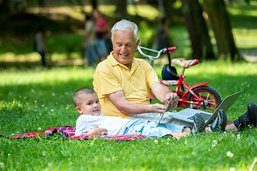 Image showing grandfather and child in park using tablet