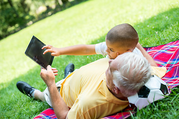 Image showing grandfather and child in park using tablet