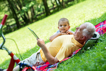 Image showing grandfather and child in park using tablet