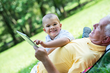 Image showing grandfather and child in park using tablet