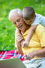 Image showing grandfather and child using laptop