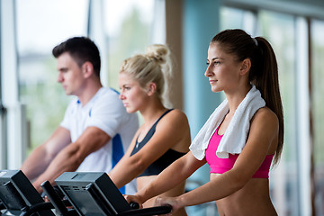 Image showing friends  exercising on a treadmill at the bright modern gym