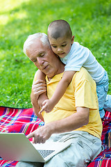 Image showing grandfather and child using laptop