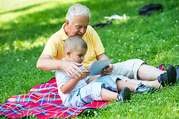 Image showing grandfather and child in park using tablet