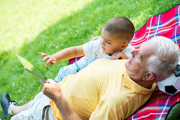 Image showing grandfather and child in park using tablet