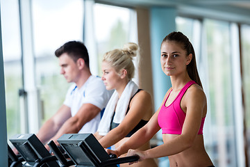 Image showing friends  exercising on a treadmill at the bright modern gym