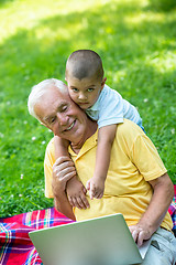 Image showing grandfather and child using laptop