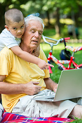 Image showing grandfather and child using laptop