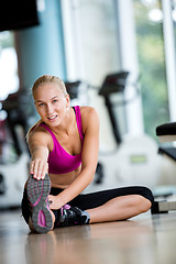 Image showing woman stretching and warming up for her training at a gym