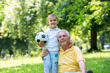 Image showing grandfather and child in park using tablet