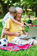 Image showing grandfather and child using laptop