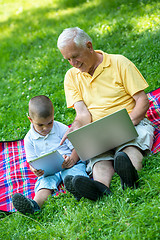 Image showing grandfather and child in park using tablet