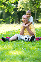 Image showing grandfather and child in park using tablet