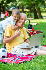 Image showing grandfather and child using laptop