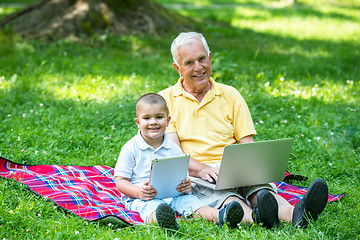 Image showing grandfather and child in park using tablet