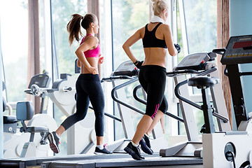 Image showing friends  exercising on a treadmill at the bright modern gym