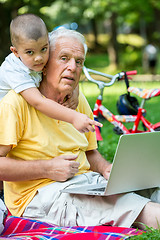 Image showing grandfather and child using laptop