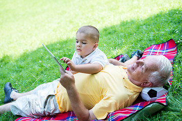 Image showing grandfather and child in park using tablet