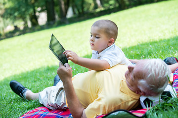 Image showing grandfather and child in park using tablet