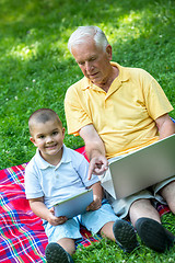 Image showing grandfather and child in park using tablet