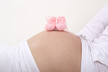 Image showing Pregnant woman with pink baby shoes on her belly