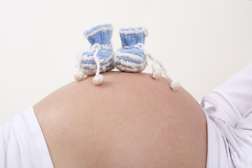 Image showing Pregnant woman with blue baby shoes on her belly