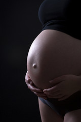 Image showing Pregnant woman in front of black background