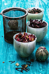 Image showing variety of dry tea leaves in jade stacks on wooden background