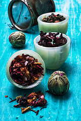 Image showing variety of dry tea leaves in jade stacks on wooden background